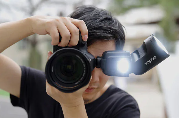فلاش اسپیدلایت گودکس Godox V1Pro-F Flash for FUJIFILM روی دوربین و مرد در حال عکاسی