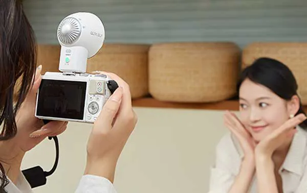 فلاش دوربین گودکس Godox Lux Elf Camera Flash روی دوربین در دست عکاس